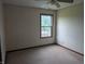 Simple bedroom featuring neutral carpet and trim, a ceiling fan, and a large window at 10150 Beresford Ct, Fishers, IN 46038