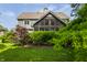 Lush backyard landscape, showcasing mature trees and the house's charming architectural details at 10974 Harbor Bay Dr, Fishers, IN 46040