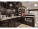 A stylish bar area features granite countertops, dark cabinetry, and modern appliances at 10974 Harbor Bay Dr, Fishers, IN 46040