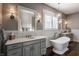 A luxurious bathroom features a standalone tub, dual vanities, and elegant fixtures at 10974 Harbor Bay Dr, Fishers, IN 46040