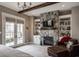 A spacious bedroom features a stone fireplace, built-in shelving, and french doors leading to the exterior at 10974 Harbor Bay Dr, Fishers, IN 46040