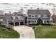 Stately home with three-car garage, meticulous landscaping, and a welcoming front porch with seating at 10974 Harbor Bay Dr, Fishers, IN 46040