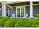 Detailed view of the home's exterior, highlighting white pillars, French doors, and charming chairs on the front porch at 10974 Harbor Bay Dr, Fishers, IN 46040