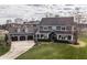 Aerial view of a grand home featuring a three-car garage, manicured lawn, and inviting front porch at 10974 Harbor Bay Dr, Fishers, IN 46040
