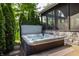 Outdoor hot tub surrounded by mature evergreens for privacy, with a view of the screened-in porch at 10974 Harbor Bay Dr, Fishers, IN 46040