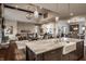 Open-concept kitchen with a large island, farmhouse sink, granite countertops, and wood floors leading to the living room at 10974 Harbor Bay Dr, Fishers, IN 46040