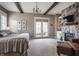 Spacious primary bedroom with a stone fireplace, exposed beams, and access to outdoor views at 10974 Harbor Bay Dr, Fishers, IN 46040