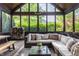 Screened-in porch with comfortable seating and wooded views through large windows at 10974 Harbor Bay Dr, Fishers, IN 46040