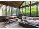Screened-in porch with comfortable seating and wooded views through large windows at 10974 Harbor Bay Dr, Fishers, IN 46040