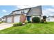 Charming townhome with a lush green lawn, colorful flower beds, and an attached one-car garage at 1124 Paradise Ct # B, Greenwood, IN 46143