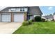 Charming townhome with a lush green lawn, colorful flower beds, and an attached one-car garage at 1124 Paradise Ct # B, Greenwood, IN 46143