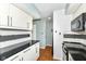 Well-lit kitchen showcasing white cabinets, black countertops, tiled backsplash, and essential appliances at 1124 Paradise Ct # B, Greenwood, IN 46143