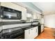 Modern kitchen with black countertops, white cabinetry, and stainless steel appliances at 1124 Paradise Ct # B, Greenwood, IN 46143