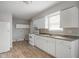 Efficient kitchen design with white appliances and cabinets, and laminate countertops, complemented by wood-look flooring at 1141 Madeira St, Indianapolis, IN 46203