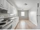 Efficient kitchen design with white appliances and cabinets, and laminate countertops, complemented by wood-look flooring at 1141 Madeira St, Indianapolis, IN 46203