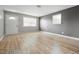 Bright living room featuring sleek wood-look floors, neutral walls, and ample natural light from two windows at 1141 Madeira St, Indianapolis, IN 46203