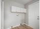 Functional mudroom area with overhead cabinet storage and hookups for laundry appliances at 1141 Madeira St, Indianapolis, IN 46203