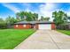 Beautiful brick home with green lawn, mature trees, and an attached two-car garage at 11630 Deanna Dr, Indianapolis, IN 46229