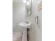 Cozy bathroom featuring a white pedestal sink, patterned wallpaper, and ceramic tile flooring at 12043 Searay Dr, Indianapolis, IN 46236