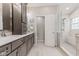 The bathroom offers a dual sink vanity, and a glass-enclosed shower and soaking tub at 12043 Searay Dr, Indianapolis, IN 46236
