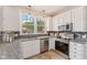 Modern kitchen with stainless steel appliances, white cabinets, and granite countertops at 12043 Searay Dr, Indianapolis, IN 46236