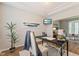 Bright home office featuring a cozy workspace, decorative plant, and an adjacent living area at 12043 Searay Dr, Indianapolis, IN 46236