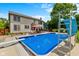Backyard pool with slide surrounded by fencing, landscaping, and patio seating at 12043 Searay Dr, Indianapolis, IN 46236