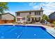 An in-ground pool is surrounded by chairs, umbrellas, and lush greenery with backyard deck at 12043 Searay Dr, Indianapolis, IN 46236