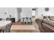 Open-concept dining area with hardwood floors, stylish table, and comfortable living space in the background at 12105 Fall Ct, Indianapolis, IN 46229