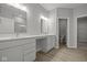 Well-lit bathroom with double vanity, neutral color palette, and modern wood-look flooring at 12500 Morning Ridge Way, Noblesville, IN 46060