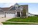 A inviting home with a two car garage, stone accents, and lush green grass at 12500 Morning Ridge Way, Noblesville, IN 46060