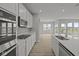 Modern kitchen with stainless steel appliances, stylish countertops, and a view into the sunlit backyard at 12500 Morning Ridge Way, Noblesville, IN 46060