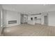 Spacious living room with a modern fireplace, recessed lighting, and a view of the adjacent kitchen area at 12500 Morning Ridge Way, Noblesville, IN 46060