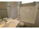 A white sink and vanity is paired with a shower-tub featuring bright white tiling from floor to ceiling at 12516 Morning Ridge Way, Noblesville, IN 46060