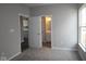 Carpeted bedroom with neutral-colored walls and doors leading to a bathroom and the kitchen at 12516 Morning Ridge Way, Noblesville, IN 46060
