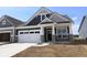 New construction exterior showcasing a two-car garage, gray siding, stone accents, and a well-manicured lawn under a clear blue sky at 12516 Morning Ridge Way, Noblesville, IN 46060