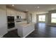 Open-concept kitchen with white cabinetry, stainless steel appliances, a central island, and sleek floors, perfect for modern living at 12516 Morning Ridge Way, Noblesville, IN 46060