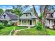 Charming home with covered front porch, manicured lawn, and mature trees at 1338 N Parker Ave, Indianapolis, IN 46201