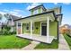 Inviting green home featuring a classic covered front porch with white columns and black trim at 1338 N Parker Ave, Indianapolis, IN 46201
