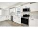 Kitchen featuring white cabinets, stainless appliances, and wood-look floors at 1338 N Parker Ave, Indianapolis, IN 46201
