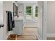 Bathroom featuring double sinks, black framed mirrors, and natural light from a large window at 14855 E State Road 46, Columbus, IN 47203
