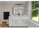 Bathroom with double sink vanity, black hardware, and a large window with nature views at 14855 E State Road 46, Columbus, IN 47203