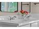 Bathroom featuring double sinks with white countertop, flowers, and modern fixtures at 14855 E State Road 46, Columbus, IN 47203