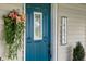 Close-up of the home's vibrant blue front door, accentuated by stylish decor and clear house numbers at 14855 E State Road 46, Columbus, IN 47203