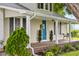 Covered front porch with a striking blue door, seating, and decorative shrubbery, offering a welcoming entrance at 14855 E State Road 46, Columbus, IN 47203