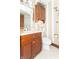 Bathroom with vertical striped wallpaper, vanity, and a mounted storage cabinet at 1497 N 200 W, Greenfield, IN 46140
