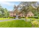 Charming brick house features a well-manicured lawn, lush landscaping, and a welcoming blue front door at 1497 N 200 W, Greenfield, IN 46140