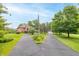 A two-story brick home has a circular driveway with an American flag and lush landscaping on an expansive lawn at 1497 N 200 W, Greenfield, IN 46140