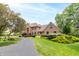 Beautiful brick home with mature trees, lush landscaping and a paved driveway leading to the front entrance at 1497 N 200 W, Greenfield, IN 46140