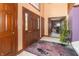 Inviting foyer featuring a dark wood door, colorful rug, and a glimpse into the adjacent office space at 1497 N 200 W, Greenfield, IN 46140